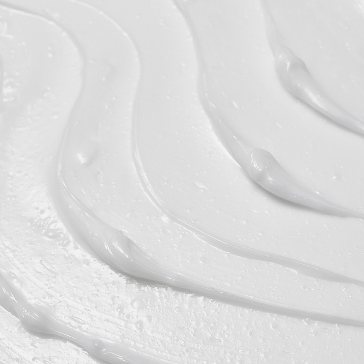 Close up texture shot of a glossy, white moisturiser